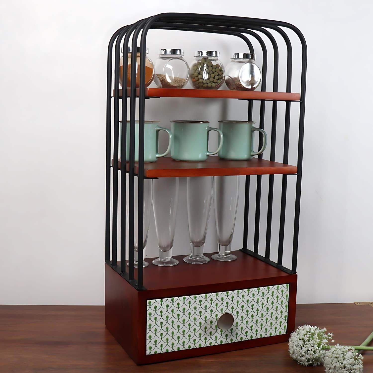 The Green bellezza Wooden Kitchen Organizer featuring three-tier walnut brown shelves with black metal frame, displaying glass spice jars, mint green mugs, and tall glasses, complemented by a decorative mint-patterned drawer at the base for versatile kitchen storage and organization.