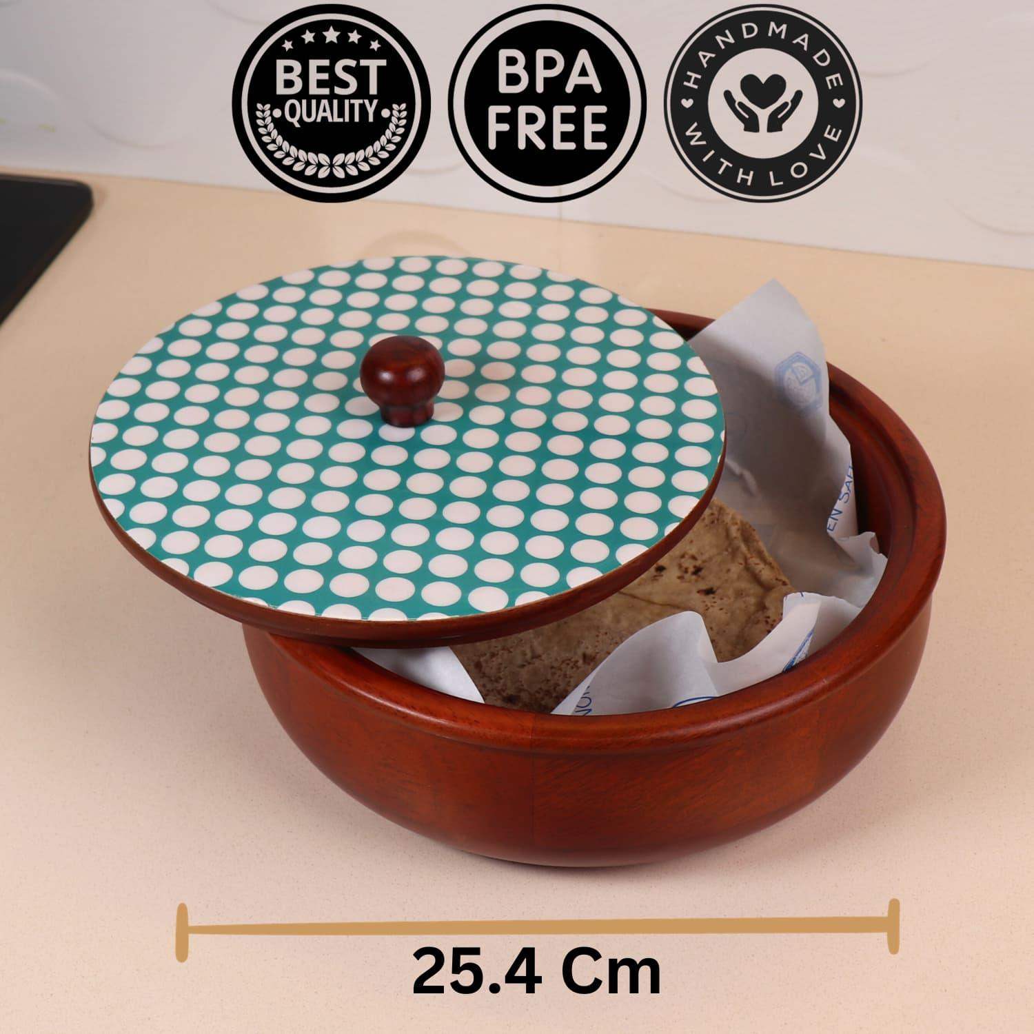 A round, brown wooden container with a removable lid featuring a green and white polka dot design. The lid is slightly lifted, revealing bread wrapped in parchment paper. Labeled "BEST QUALITY," "BPA FREE," "HANDMADE WITH LOVE," and showing the diameter as 25.4 cm, it's the best chapati box online in India—The Dot Legacy Chapati Box by LOOSEBUCKET.