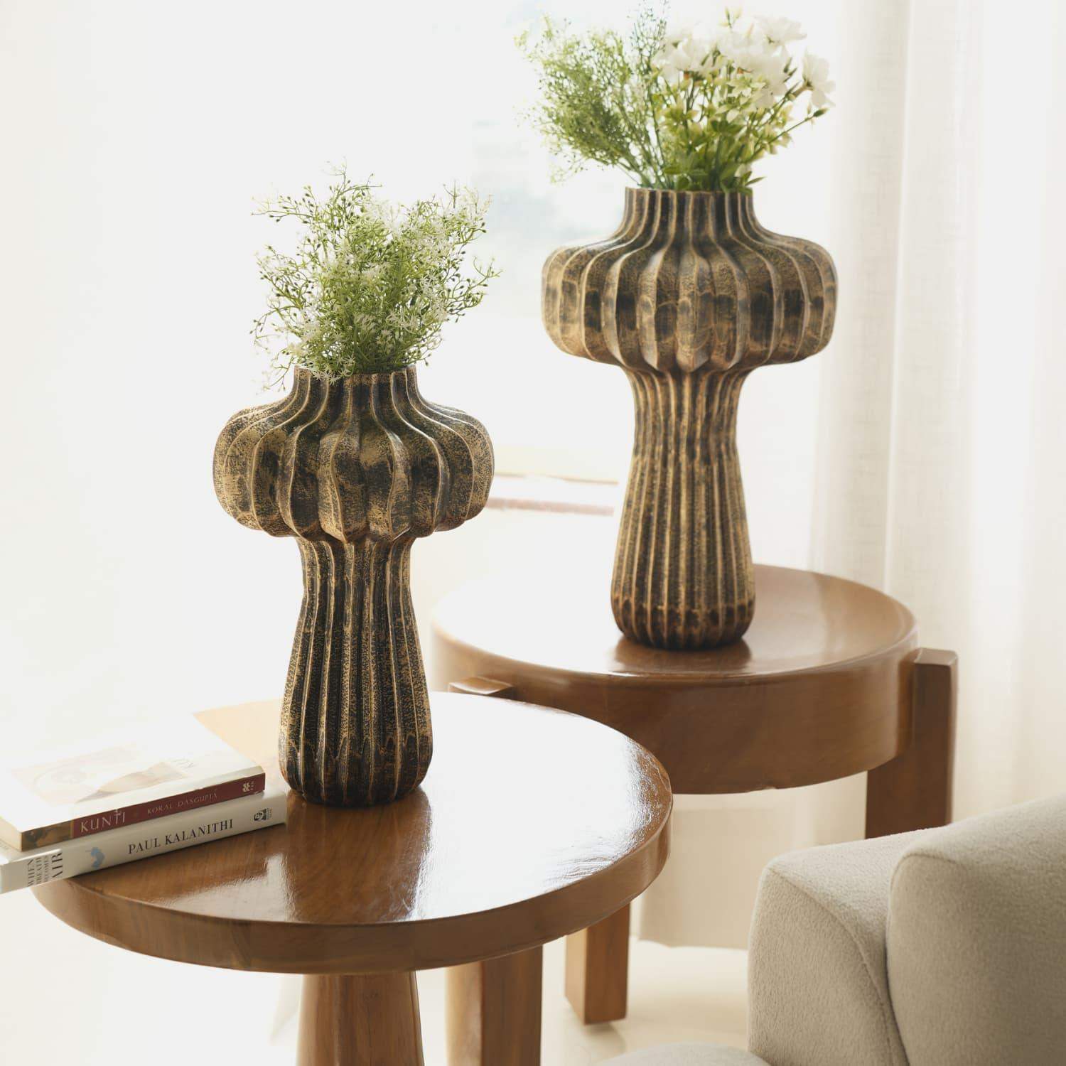 Premium Vintage Portobello Aluminum Vases displayed on round wooden side tables, featuring mushroom-shaped design with ribbed texture in antique golden brown finish, decorated with delicate white flowers and greenery, showcasing both 16-inch and 12-inch sizes in an elegant home setting.