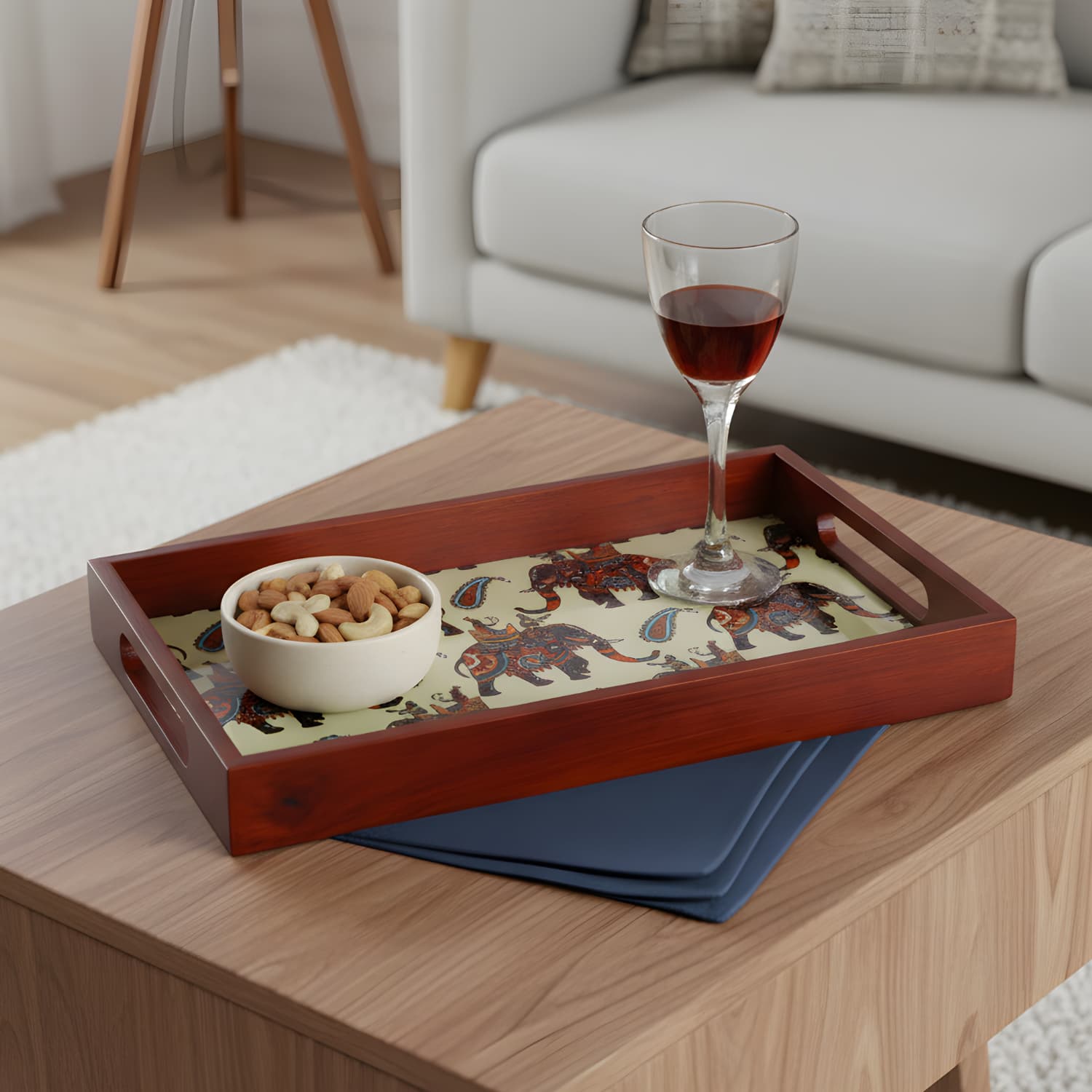 Loosebucket Walking Elephant Wooden tray with a bowl of snacks and a glass of red wine on a wooden table.