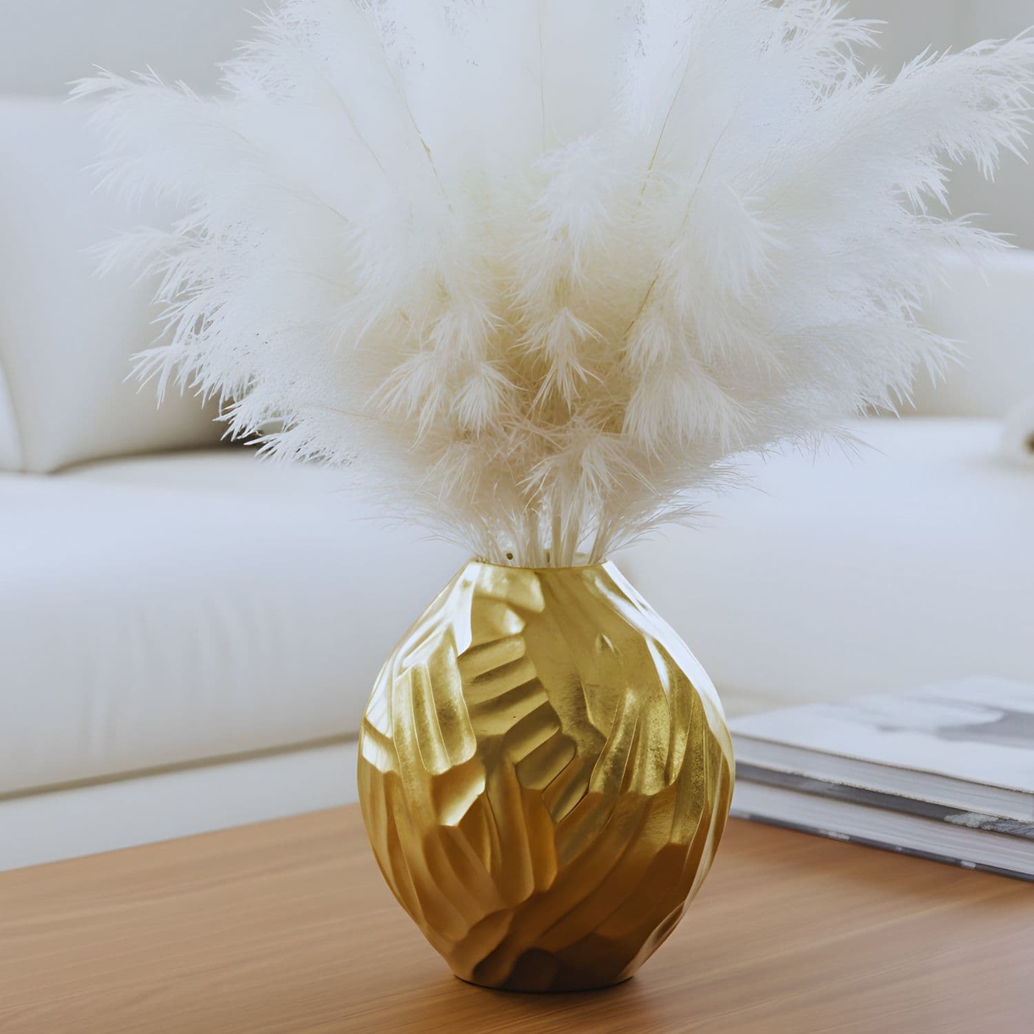 Loosebucket THE STARRY SWIRL Aluminum Vase, Golden vases placed on table and beautiful living room setting behind,Gold decorative vase with white feathers on a wooden surface