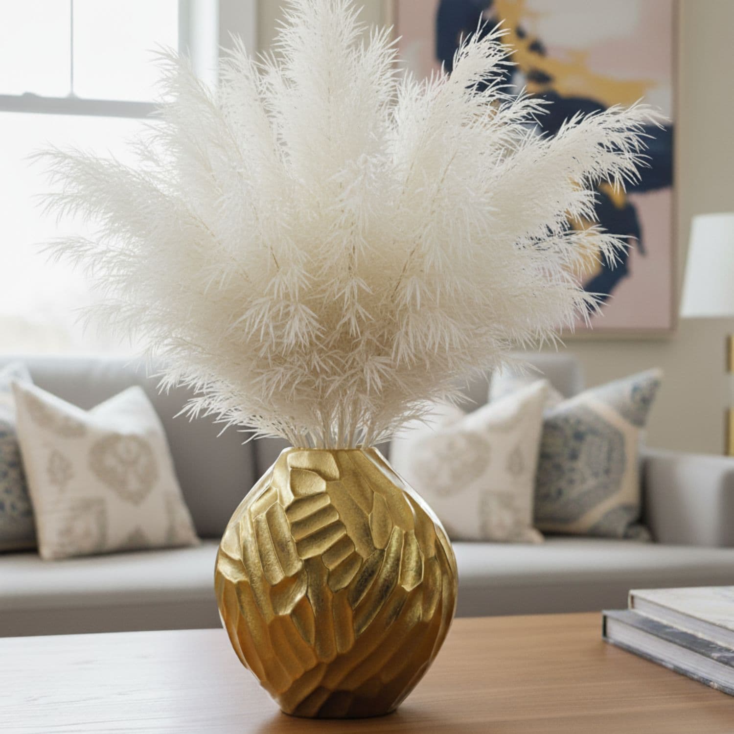Loosebucket THE STARRY SWIRL Aluminum Vase, Golden vases placed on table and beautiful living room setting behind,Decorative gold vase with white pampas grass on a table in a living room.