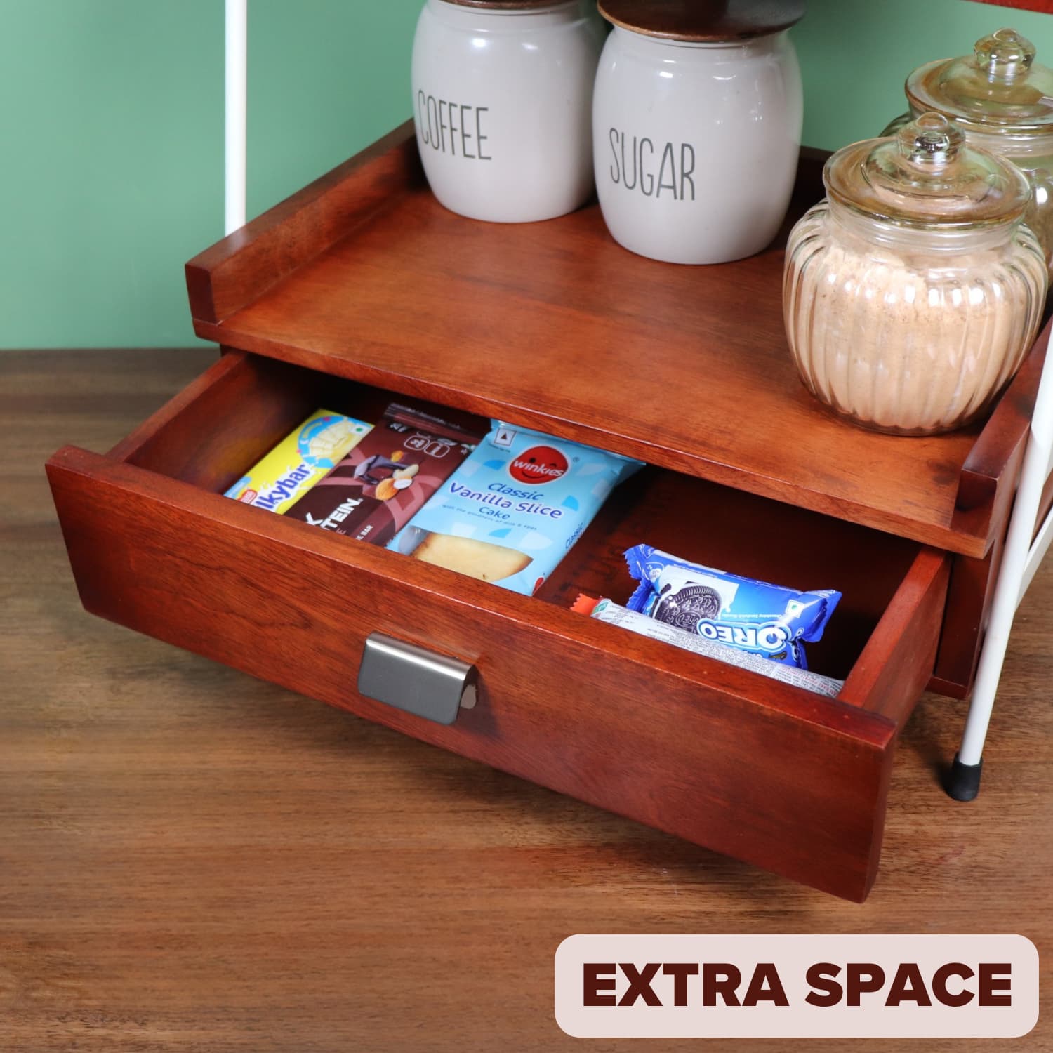 Loosebucket Wooden Kitchen organizer  snack tray with open drawer containing snacks, on a wooden surface with a green wall background.