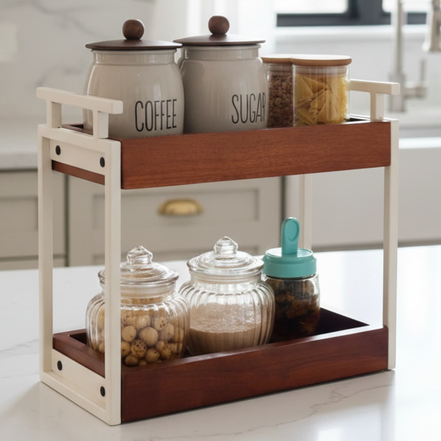 Loosebucket The Blanc A two-tiered organizer with a walnut finish on the upper shelf and ivory metal frame. It is displayed with various containers on it, such as jars and containers with a 'COFFEE' and 'SUGAR' label.