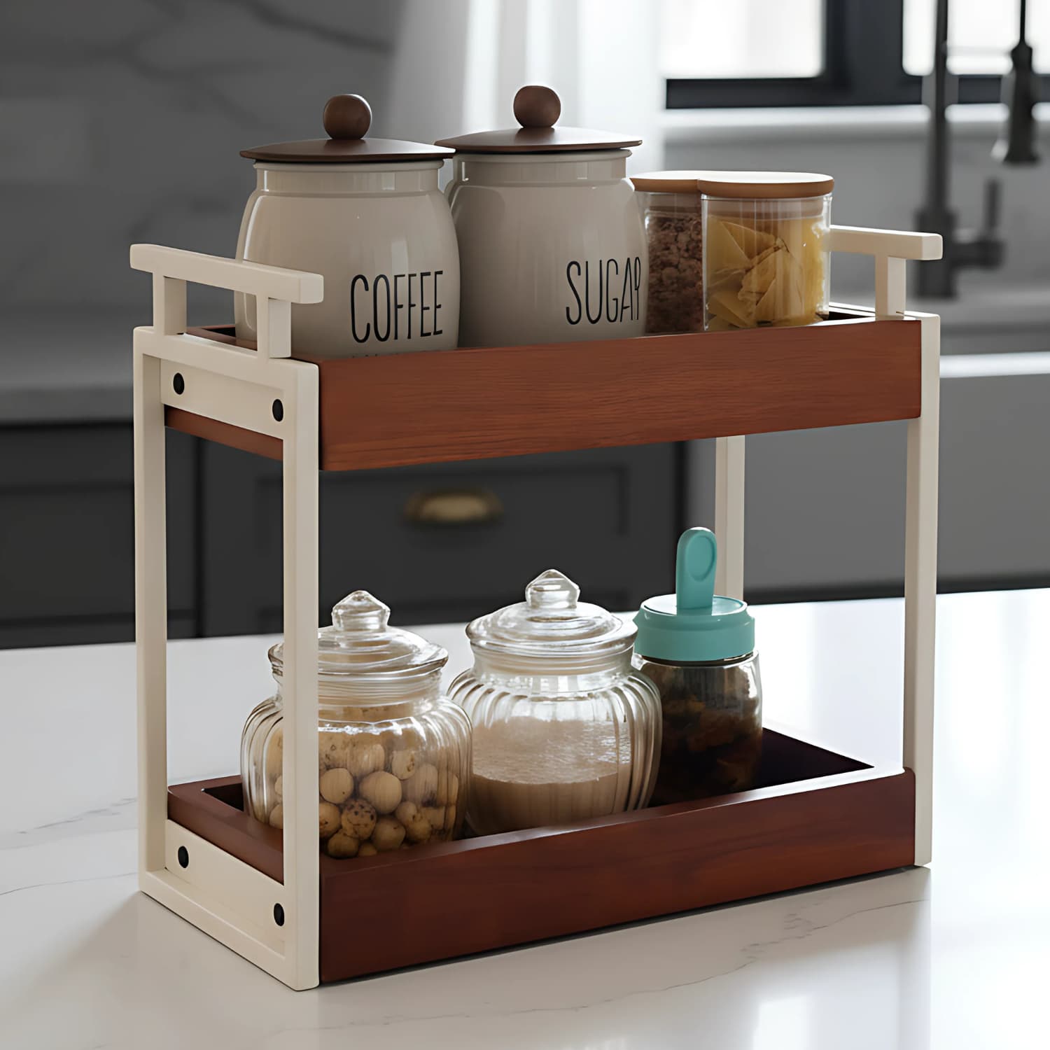 Loosebucket The Blanc A two-tiered organizer with a walnut finish on the upper shelf and ivory metal frame. It is displayed with various containers on it, such as jars and containers with a 'COFFEE' and 'SUGAR' label.